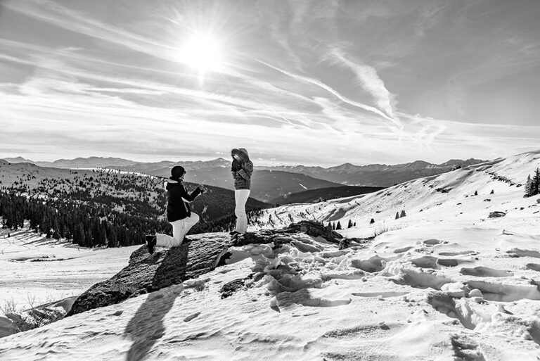 Black and white photograph of marriage proposal near Vail, CO with Nova Guides Snowmobiles.